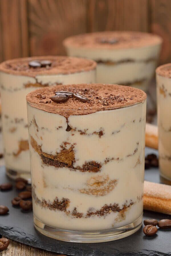 three desserts are sitting on a table with coffee beans and cinnamon sticks around them