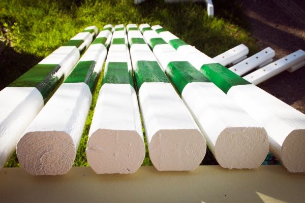 several pieces of white and green painted wood sitting on top of a cement bench in the grass