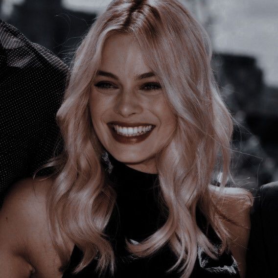 a woman with blonde hair smiling at the camera