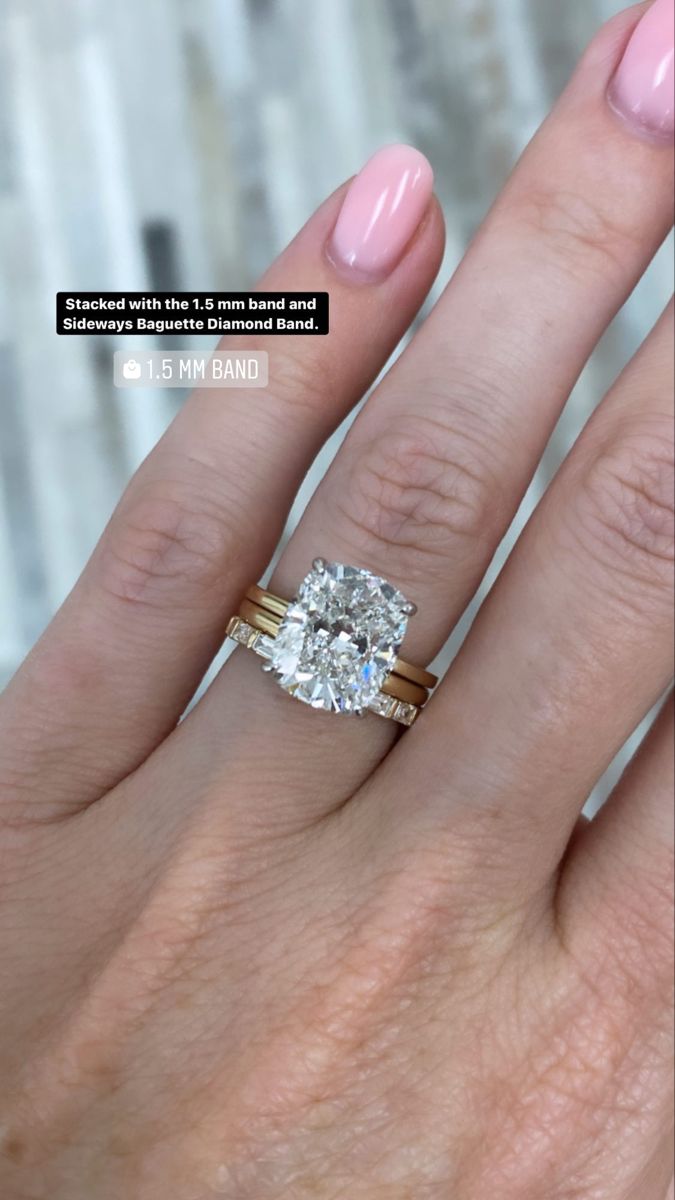 a woman's hand with two engagement rings on it