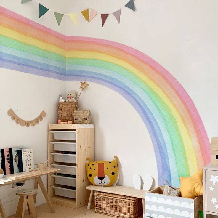 a child's room with a rainbow painted on the wall