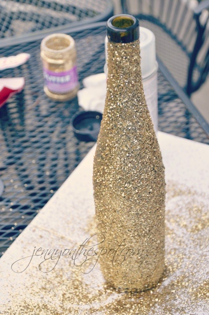 a bottle sitting on top of a table covered in gold flecks and glitter