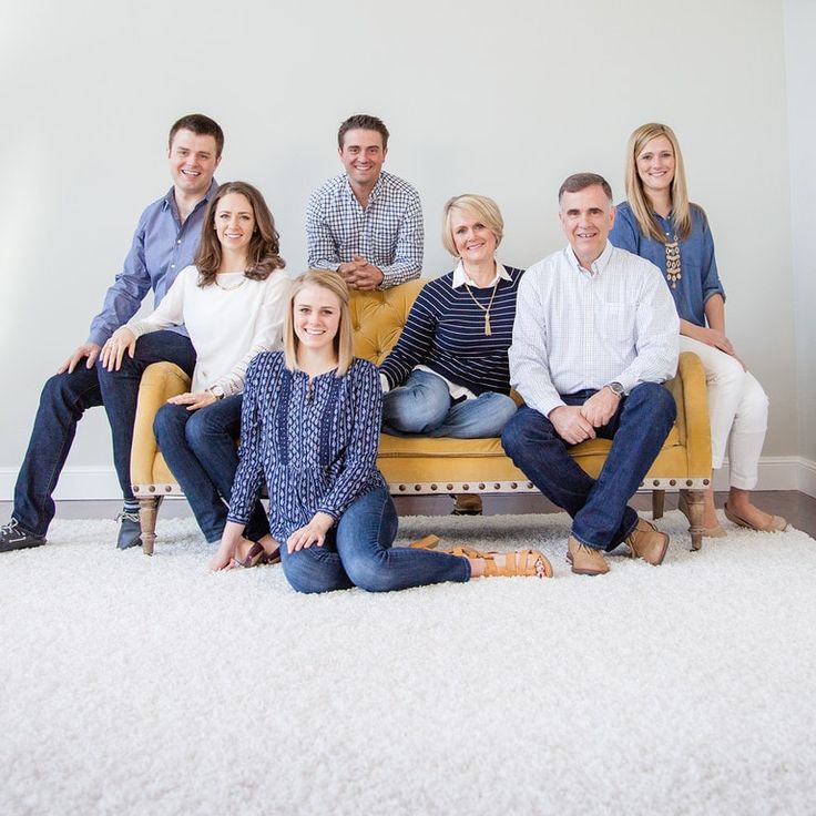 a group of people sitting on top of a couch in front of a white wall