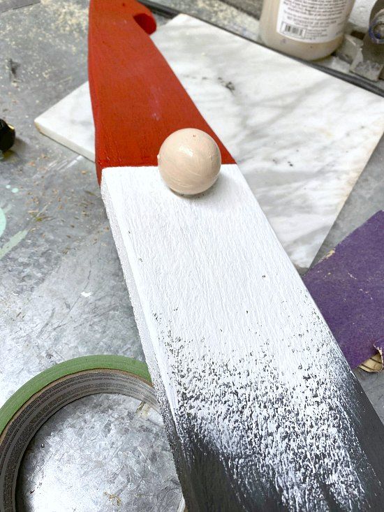 a piece of wood sitting on top of a table next to some tape and glue