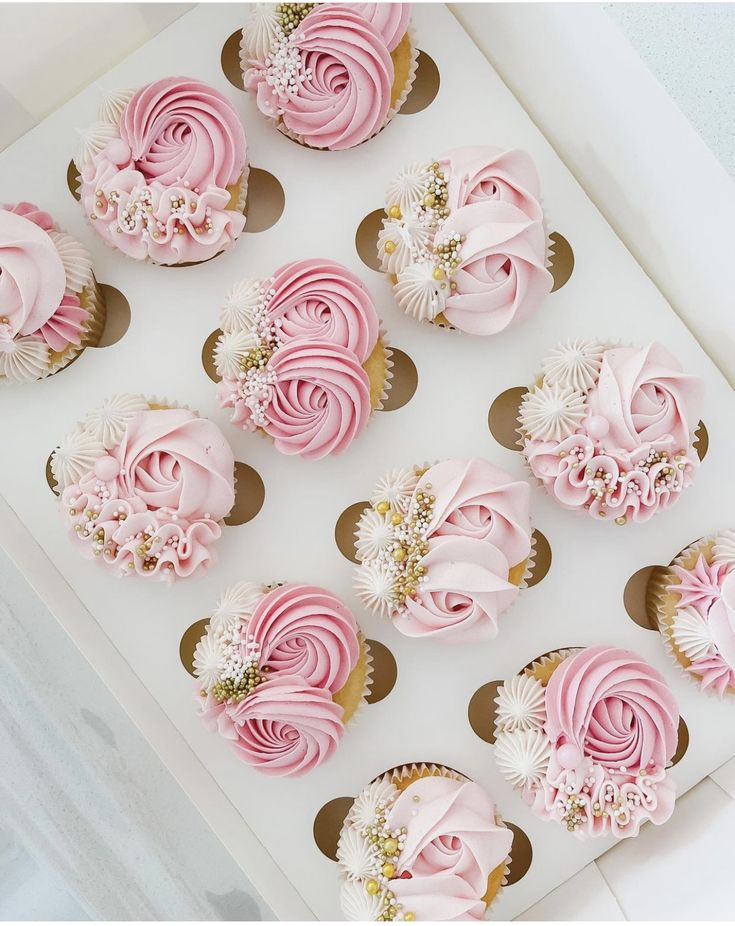 cupcakes with pink and white frosting in a box