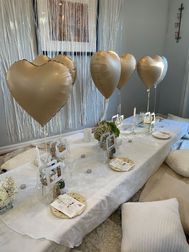 the table is set up with heart shaped balloons