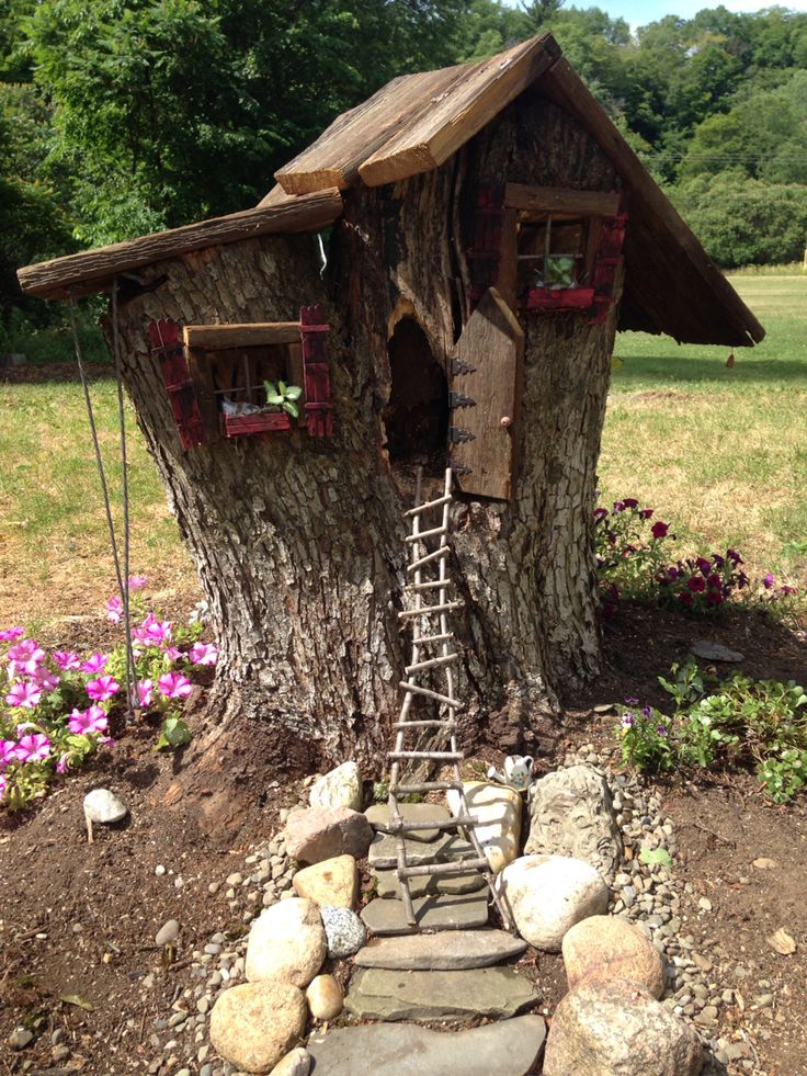 a tree house built into the side of a tree trunk with steps leading up to it