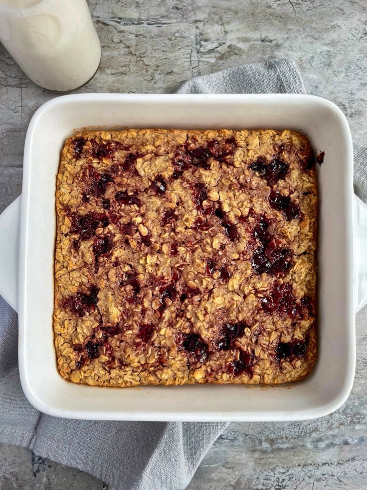 a square casserole dish filled with oatmeal and fruit