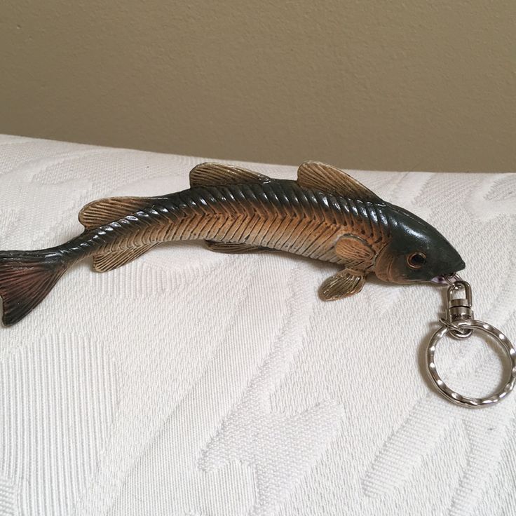 a fish shaped keychain with a metal ring on it's back end