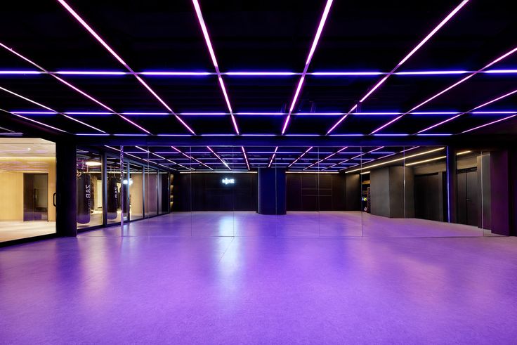 an empty room with purple lighting in the ceiling