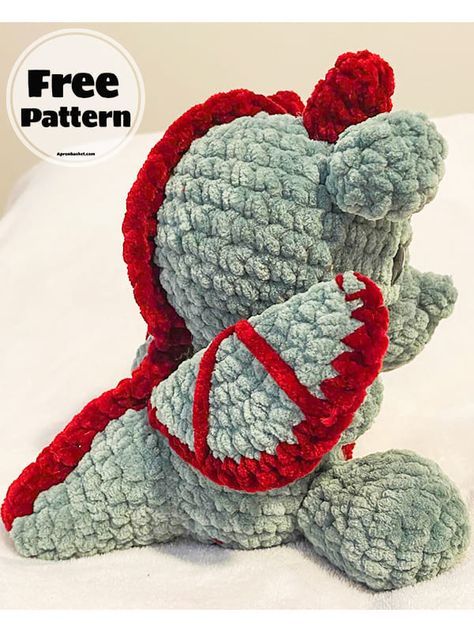 a gray and red teddy bear sitting on top of a white bed with the caption free pattern