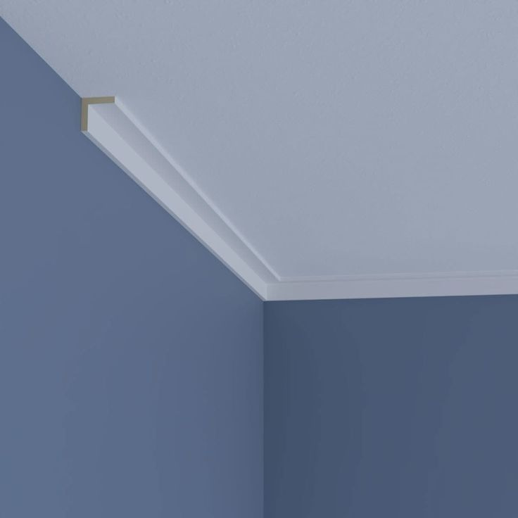 the corner of a room with blue walls and a light fixture on the ceiling above it