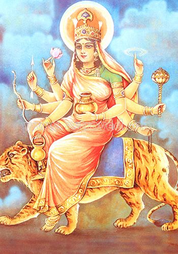 the goddess sitting on top of a tiger with two candles in her hand and an animal nearby