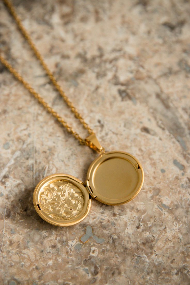 Our Lyon Locket is filled with memories and opens up to hold a picture of a loved one. PRODUCT DETAILS 18K Gold Plated Stainless Steel locket opens up Nickel free chain length: 50cm (19.5") pendant size: 2.8cm (1") CARE For the longest shine avoid contact with water, perfume, moisturizer and hairspray. We recommend you remove your jewelry when showering, exercising, at the beach, or swimming in chlorinated water. All pieces featuring natural gemstones are very precious and need to be treated wit Gold Spiritual Locket Necklace For Anniversary, Round Pendant Locket Necklace As Gift, Tarnish Resistant Round Pendant Locket Necklace Gift, Tarnish Resistant Round Pendant Locket Necklace, Gift Amulet Style Coin Necklace With Adjustable Chain, Gift Round Pendant Locket Necklace, Spiritual Medallion Locket Necklace As Gift, Spiritual Locket Necklace For Anniversary, Yellow Gold Medallion Locket Necklace In Amulet Style