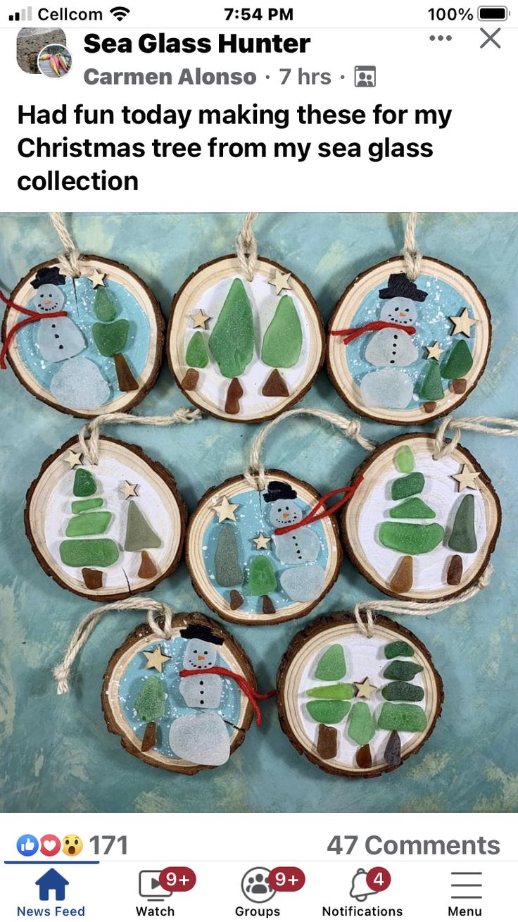 christmas ornaments with snowmen and trees are hanging from wood slices on a blue background