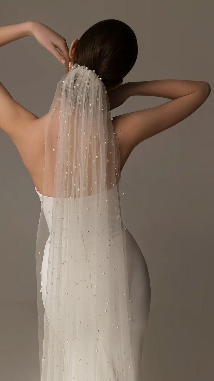 the back of a woman wearing a white veil