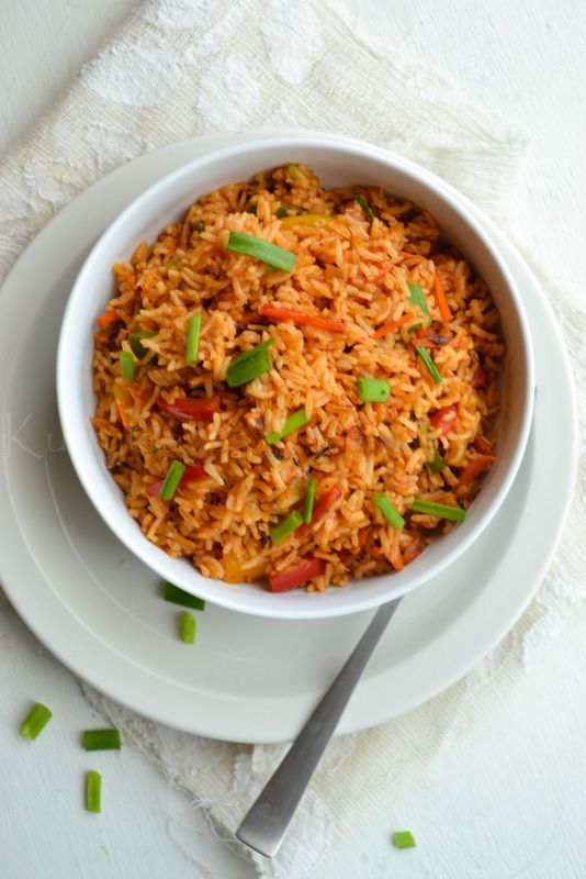 a white bowl filled with rice on top of a plate next to a knife and fork