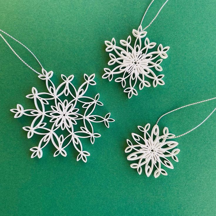 two white snowflakes sitting on top of a green surface