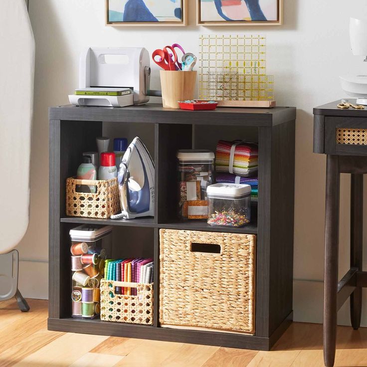 a shelf with baskets, scissors and other crafting supplies on it in a living room