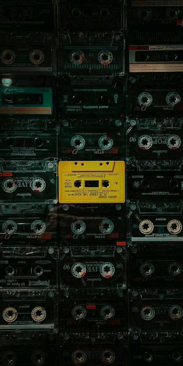 there are many cassettes stacked on top of each other in this room, and one is yellow