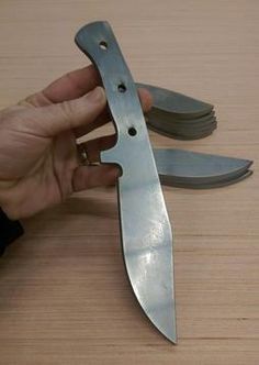 a person is holding a knife on top of another blade that has been cut into smaller pieces