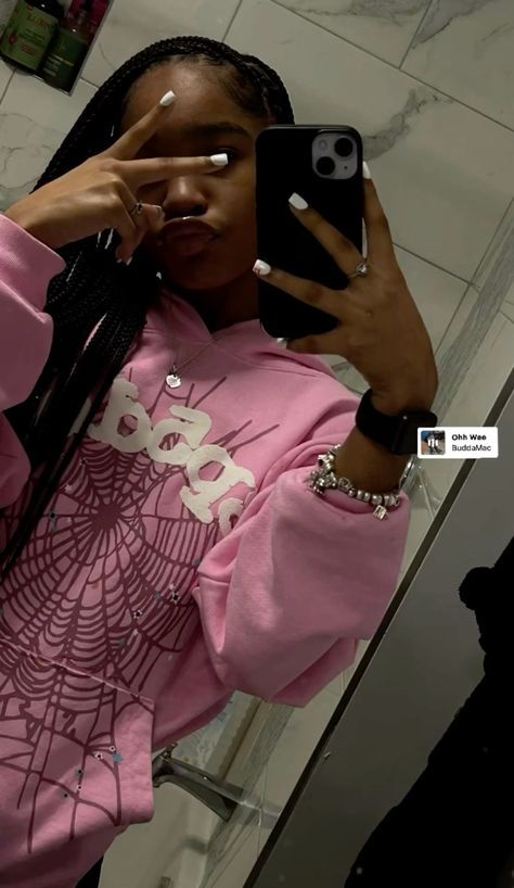 a woman is taking a selfie in the mirror with her cell phone while wearing a pink sweatshirt