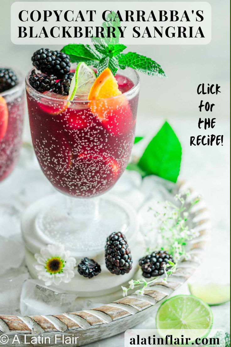 the cocktail is garnished with blackberries and lime