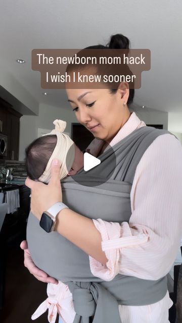 a woman holding a baby in a grey sling with the caption'the newborn mom hack i wish i knew soon '