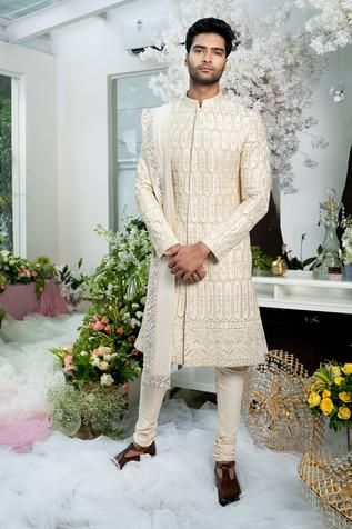 Ivory sherwani with floral zardozi embroidery and band collar. Comes with churidar and stole.
Components:3
Pattern:Embroidery
Type of Work:Zardozi
Neckline:Band
Sleeve Length:Full
Fabric:Twill Silk and Cotton Lycra
Color:White
Other Details:
Stole with embroidered border
Side slits
Closure: Concealed button front
Occasion:Groom - Aza Fashions Varun Chakkilam, Sherwani Groom Wedding, Stole For Men, Ivory Sherwani, Blue Sherwani, Embroidered Sherwani, Sherwani Groom, Zardozi Embroidery, Classy Suits