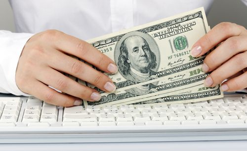 a person holding money in their hands while typing on a keyboard with the words payday loan