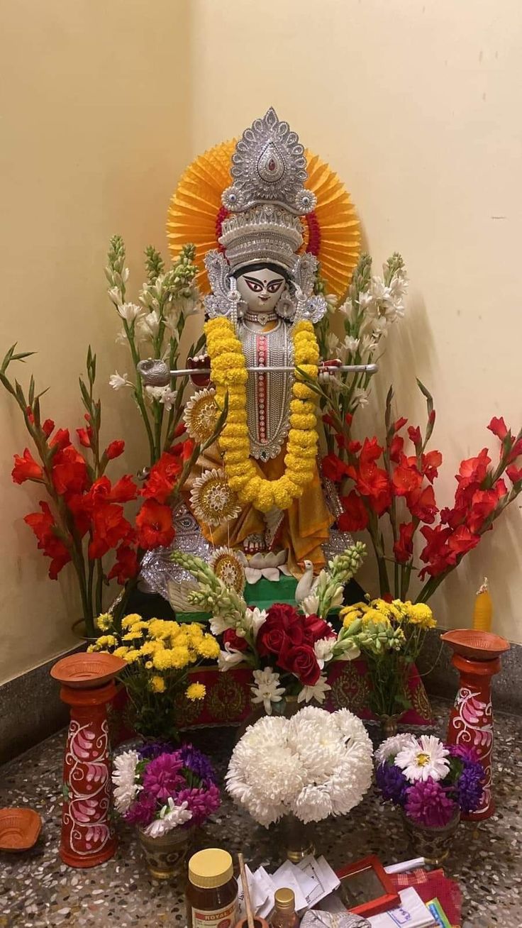 the statue is surrounded by flowers, candles and other things to decorate it for diwaling