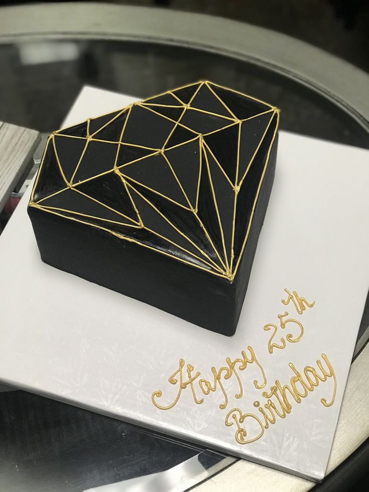 a black and gold diamond shaped birthday cake