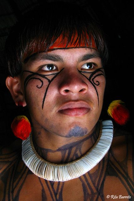 a man with tattoos on his face and chest