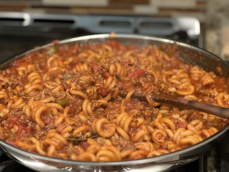 a pan filled with pasta and meat on top of a stove