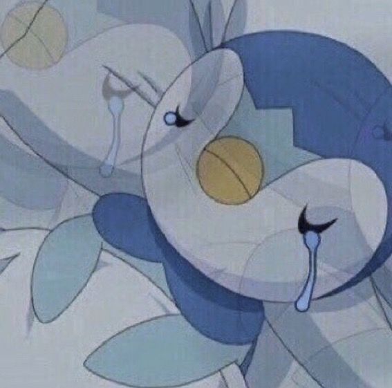 a blue and white teddy bear sitting on top of a bed next to a pillow