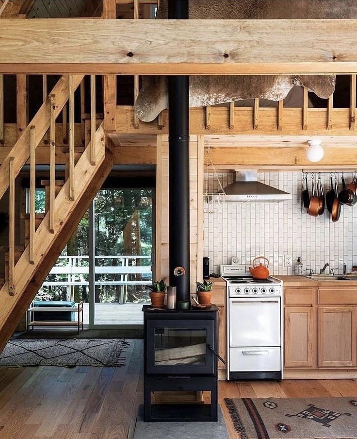 a kitchen with an oven, stove and stairs leading up to the loft above it