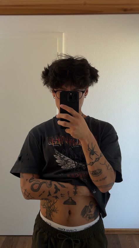 a man taking a selfie in front of a mirror with tattoos on his body