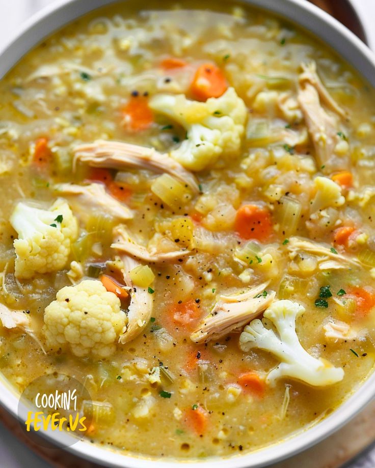 a white bowl filled with chicken and cauliflower soup