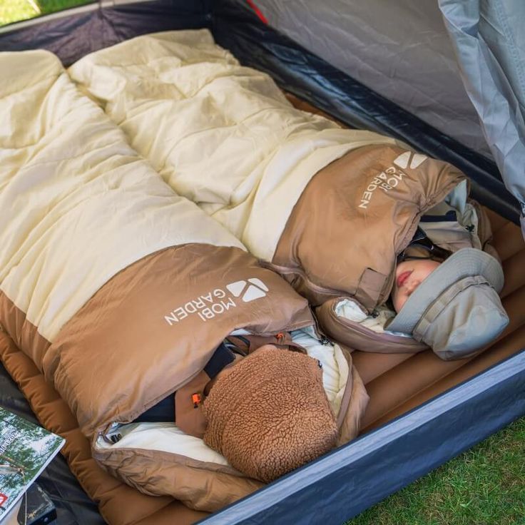 a child sleeping in an inflatable bed on the grass