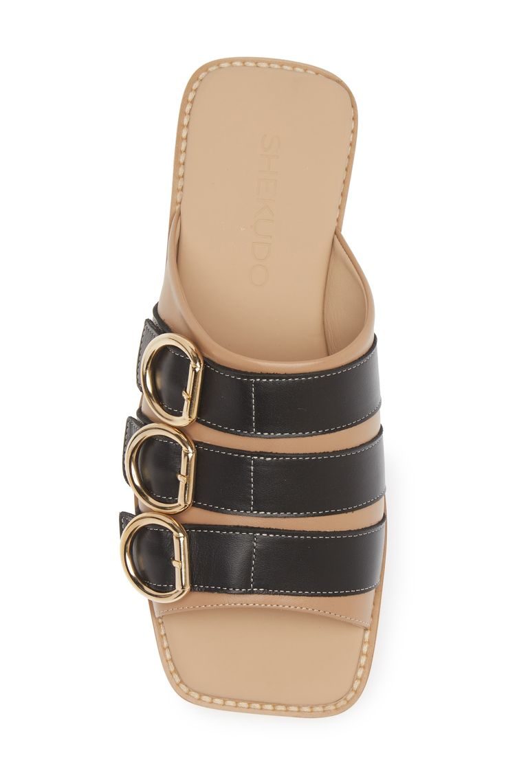 Whether you're polishing up your casual office look or dressing up for brunch, this buckled slide sandal will enhance a variety of looks. Leather upper and lining/rubber sole Made in Portugal Black Owned/Founded Open Toe Slides With Gold Buckle For Spring, Spring Open Toe Slides With Gold Buckle, Spring Slides With Gold Buckle And Open Toe, Elegant Mules With Buckle Closure In Slide Style, Elegant Slide Mules With Buckle Closure, Designer Black Sandals With Rectangular Buckle, Trendy Flat Heel Mules With Buckle Closure, Classic Flat Slides With Buckle Closure, Designer Summer Slides With Tang Buckle