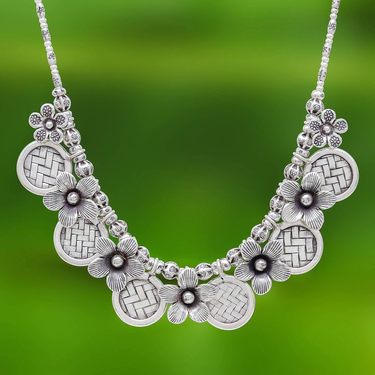 This pretty and feminine necklace is presented by Pakaon Sojintarit who works with Karen hill tribe silversmiths. The pendant is crafted of 950 Thai silver with a series of alternating flower charms and basketweave discs. The pendant centers a strand of artisan-stamped 950 silver beads. Traditional Sterling Silver Flower Pendant Necklace, Traditional Sterling Silver Nickel Free Necklace, Traditional Nickel-free Sterling Silver Necklace, Adjustable Silver Bohemian Flower Necklace, Traditional Adjustable Sterling Silver Necklaces, Artisan Silver Necklace Stamped 925, Adjustable 925 Stamped Necklaces, Bohemian Silver Necklace With Sterling Silver, Traditional Silver Necklace With Flower Pendant