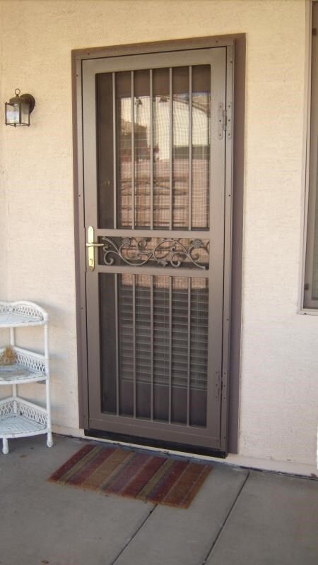 the front door to a house with an iron grill on it's side walk