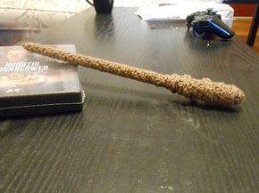 a rope wrapped around a book on top of a table next to a video game controller