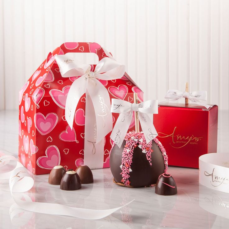 some chocolates are sitting next to each other on a table with ribbons and bows