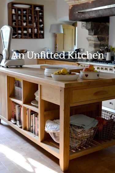 an unfinished kitchen island with baskets on the bottom and bookshelves in front of it