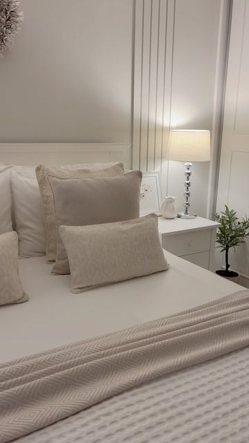 a bed with white sheets and pillows in a room