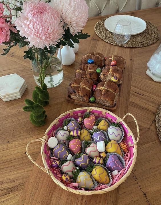 a basket filled with lots of candy sitting on top of a table next to flowers