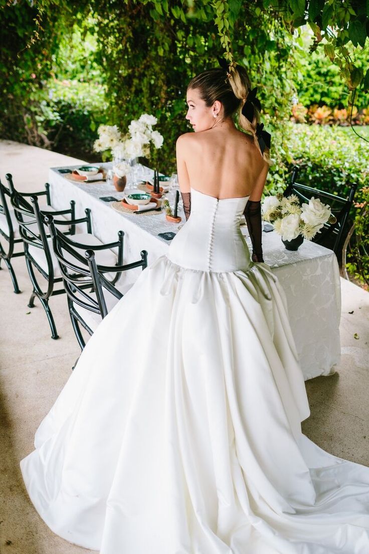 a woman in a wedding dress sitting at a table