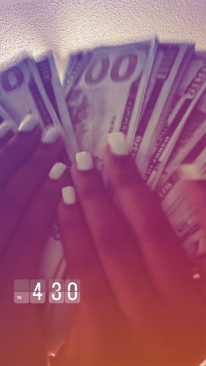 a woman's hands holding money in front of her face with the number 350 on it