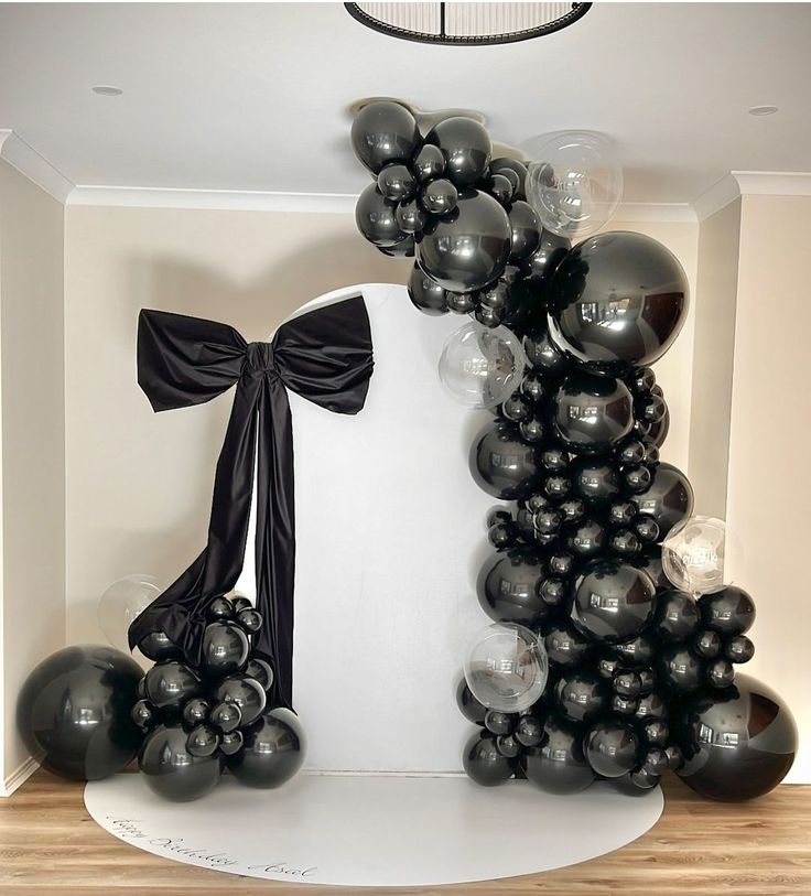 black and silver balloons are on display in a room